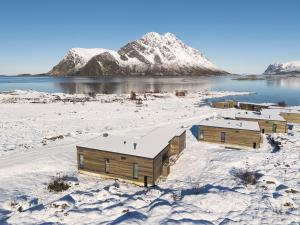 un gruppo di case nella neve su un lago di Luxury Lodge in Lofoten - jacuzzi & sauna - LL20 a Lyngværet