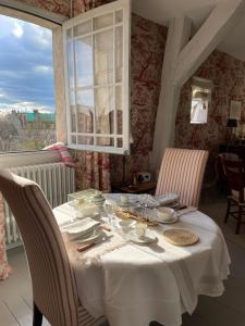 a dining room with a white table and chairs at Belle Fontaine in Bourges