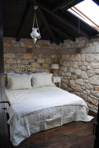 sypialnia z łóżkiem w kamiennej ścianie w obiekcie Halkidiki Luxurious Stonehouses w mieście Psakoudia