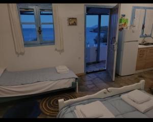 キスノスにあるThe Dream House on the Beach-Ground Floorのベッド2台付きの部屋、冷蔵庫付きのキッチンが備わる客室です。