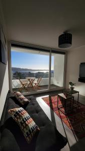 a living room with a couch and a large window at Departamento Concepción in Concepción