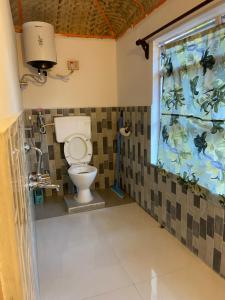 a bathroom with a toilet and a window at Evelyn homestay and camps in Dawki