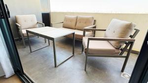 Dos sillas y una mesa en una sala de espera. en DakarByDays-DBD003-Appartement Adèle 1 chambre, en Dakar