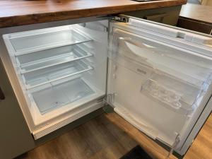 an empty refrigerator with its door open in a kitchen at Apartment Relax in Trittau