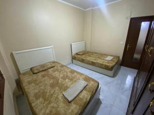 2 Betten in einem kleinen Zimmer mit einer Tür in der Unterkunft Downtown Cairo Urban Retreat in Kairo
