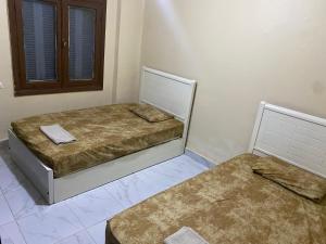 2 Einzelbetten in einem Zimmer mit 2 Ottomanen in der Unterkunft Downtown Cairo Urban Retreat in Kairo