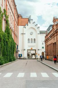 an empty street in a city with buildings at Uumen Hotels - Tampere, Finlayson in Tampere