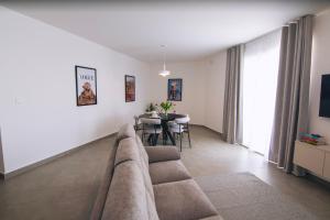 a living room with a couch and a table at Egħżien Suite A2 Access to Tranquil Shared Pool in Xagħra