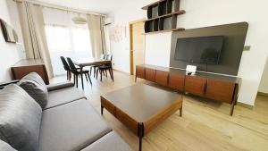 Una sala de estar con un sofá y un televisor de pantalla plana. en DakarByDays-DBD003-Appartement Adèle 1 chambre, en Dakar
