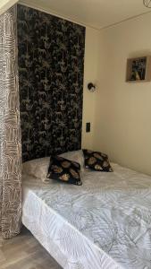un letto con due cuscini sopra in una camera da letto di Petit appartement cosy Miribel a Miribel