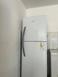 a white refrigerator freezer in a kitchen next to a wall at Depto 3 in Río Cuarto