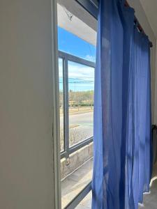 a window with a blue curtain in a room at Depto 3 in Río Cuarto
