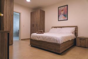 沙拉The Valley Collection - Suite B3的一间卧室配有一张大床和一个木制橱柜