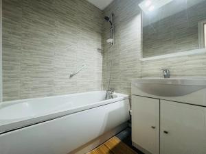 ein Badezimmer mit einer weißen Badewanne und einem Waschbecken in der Unterkunft Cozy apartment near thermal baths in Balaruc-les-Bains