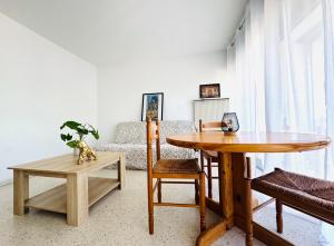 ein Wohnzimmer mit einem Tisch und einem Sofa in der Unterkunft Cozy apartment near thermal baths in Balaruc-les-Bains