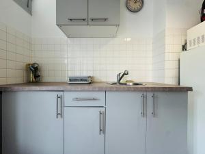 eine Küche mit weißen Schränken und einer Spüle in der Unterkunft Cozy apartment near thermal baths in Balaruc-les-Bains