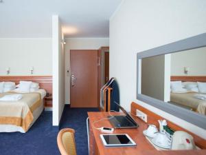 Pokój hotelowy z 2 łóżkami i biurkiem z laptopem w obiekcie Hotel Nadmorski w mieście Gdynia