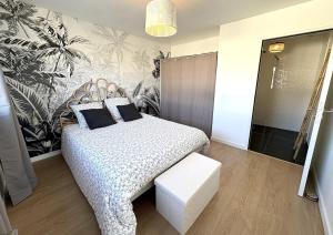 a bedroom with a bed and a bench in it at Villa Armor Vue mer et Spa in Carantec +31 photos