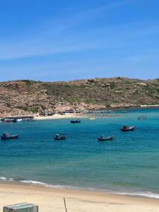 a group of boats in the water on a beach at Nhà Nghỉ Phát Lợi in Quy Nhon