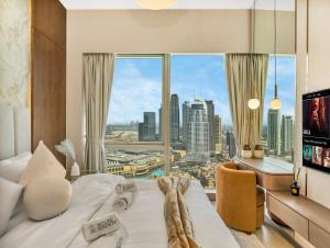 Crown Jewel 2 Bedroom Apartments I Iconic Burj Khalifa and Fountain Views I Free Parking, Gym, Pool, Wi-Fi and PS5 I by Skyline Serenity في دبي: غرفة فندقية بسرير كبير ونافذة كبيرة
