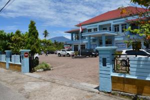 a blue building with a parking lot in front of it at Koto Hilalang Homestay in Bukittinggi