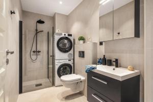a bathroom with a toilet and a sink and a shower at Rosenberg Apartments in Bergen +91 photos