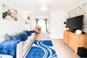 a living room with a couch and a flat screen tv at Polperro House - Chic & Stylish Home in Orpington