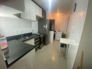 a kitchen with a refrigerator and a counter top at Lindo Apto 404 bem localizado Piratuba SC in Piratuba