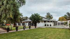 a white house with a lawn in front of it at Cornerstone Manor Kathu in Kathu