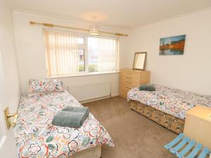 a bedroom with two beds and a window at 14 Orchard Road in Seaview