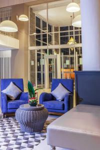 een woonkamer met twee blauwe stoelen en een tafel bij Dunes d'Or Ocean Club in Agadir