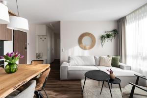 a living room with a white couch and a table at Scala City Center Premium Apartments with Parking by Lion Apartments in Gdańsk