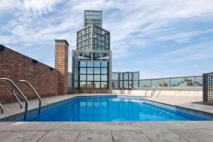 a swimming pool with a tall building in the background at NH Córdoba Panorama in Córdoba