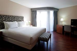 a hotel room with a large bed and a window at NH Córdoba Panorama in Córdoba