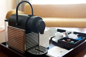 a coffee maker sitting on top of a table at NH Córdoba Panorama in Córdoba +26 photos