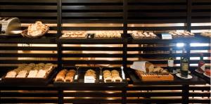 a display case with different types of bread and pastries at NH Córdoba Panorama in Córdoba