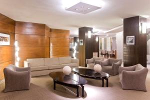 a living room with a couch and tables and chairs at NH Córdoba Panorama in Córdoba
