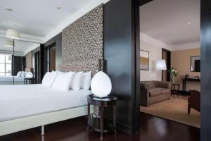 a bedroom with a white bed and a living room at NH Collection Buenos Aires Centro Histórico in Buenos Aires