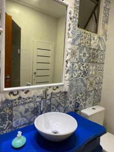 a bathroom with a white sink and a mirror at Seasonal Rental Itacimirim in Camacari
