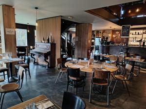 un restaurante con mesas, sillas y un piano en Kyriad Laon, en Laon