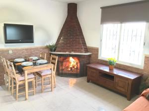 sala de estar con chimenea, mesa y sillas en Finca Can Titos, en Llucmajor