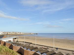 a view of a beach with a pier and the ocean at Oceans 44 in Sewerby