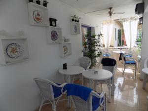 a dining room with white tables and chairs at Hostal Villa Maruja in El Arenal