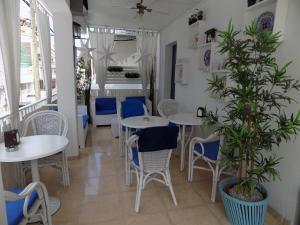 a restaurant with tables and chairs and a potted plant at Hostal Villa Maruja in El Arenal +30 photos