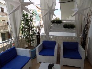 a balcony with two blue chairs and a window at Hostal Villa Maruja in El Arenal