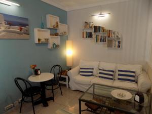 a living room with a white couch and a table at Hostal Villa Maruja in El Arenal