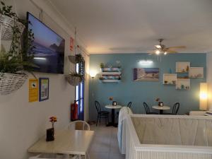a dining room with two tables and a tv on the wall at Hostal Villa Maruja in El Arenal
