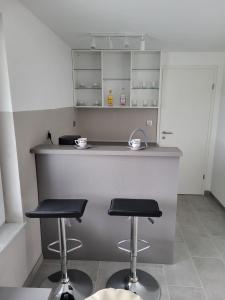a kitchen with two bar stools and a counter at Holiday home Baron in Radeče