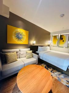 a hotel room with a bed and a couch and a table at Novotel Suites Residences Mandaluyong-Makati by Marj in Manila +6 photos