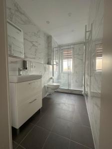 a white bathroom with a sink and a toilet at Haus Alpina in Garmisch-Partenkirchen +58 photos